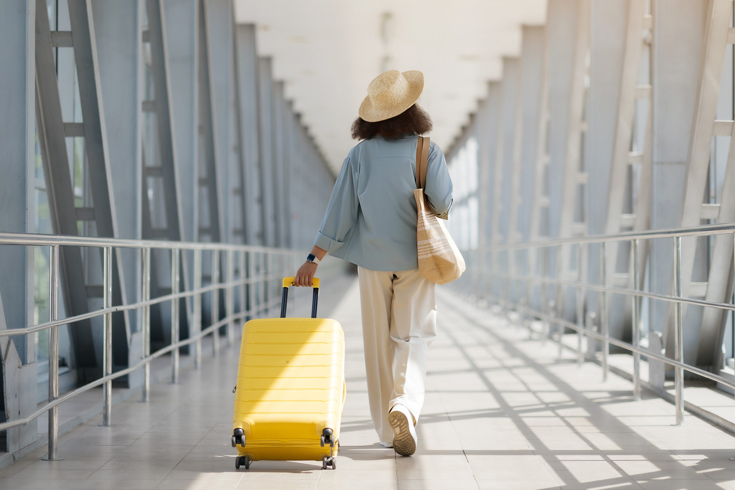 A Tourist walking with her luggage in an airport